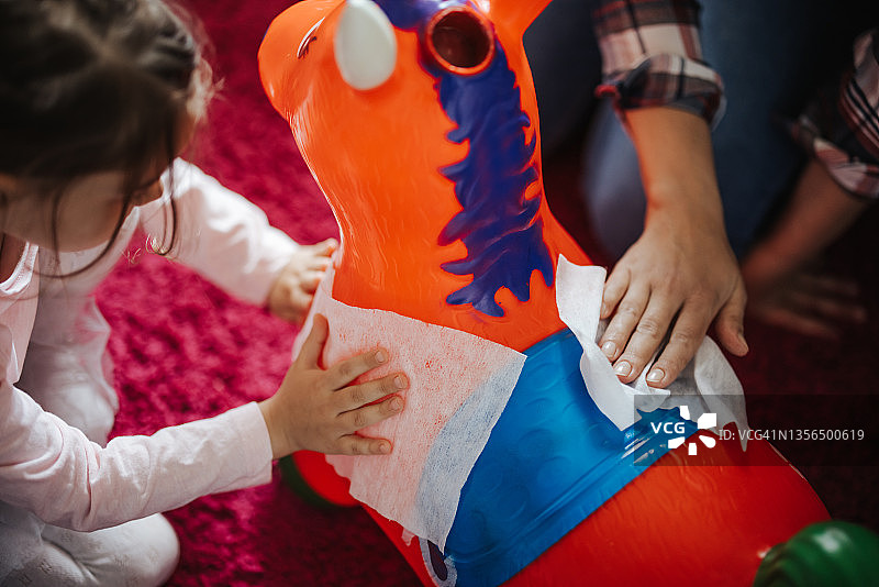 母亲和女儿在家打扫游戏室图片素材