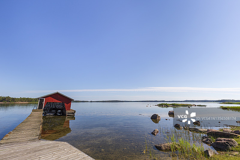 芬兰奥兰群岛夏季阳光明媚的一天，木制码头、船库和海洋图片素材