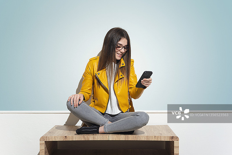 女人在桌旁看智能手机图片素材