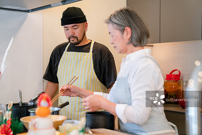 年长的女人教成年儿子如何做饭图片素材