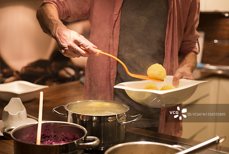 男人烹饪土豆丸子和红卷心菜图片素材