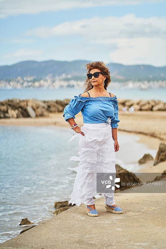 站在海湾岸边的时尚中年女性图片素材