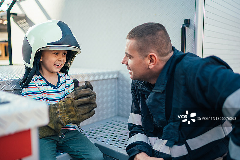 消防员在工作时照顾儿子图片素材