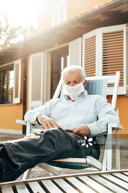 居家隔离期间阅读书籍的老年男人图片素材