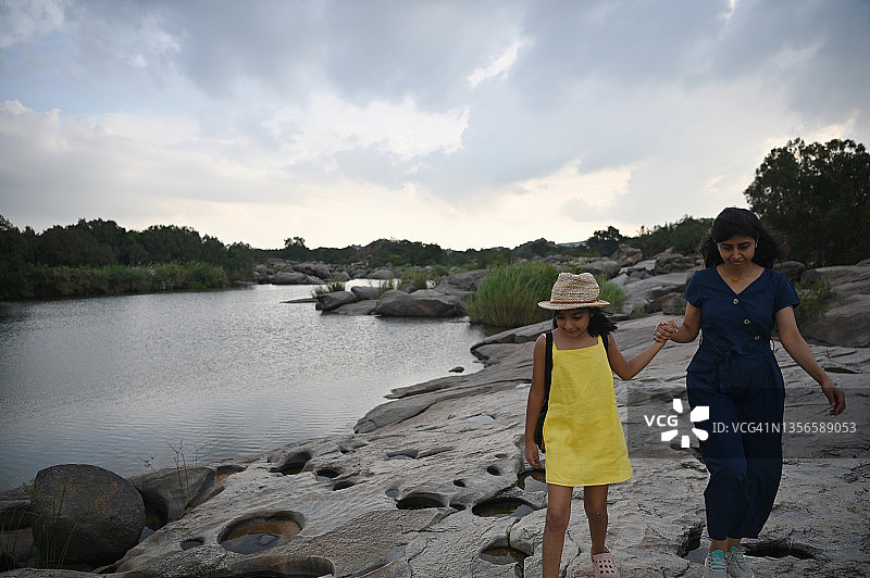 母女在卡纳塔克邦亨比的巨石附近徒步旅行图片素材