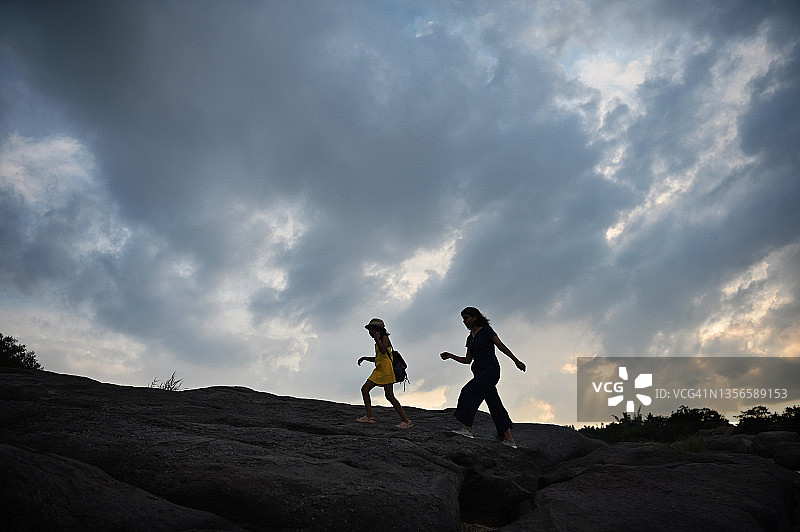 母女在卡纳塔克邦亨比日落时一起徒步旅行图片素材