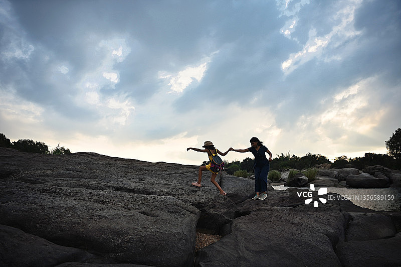 母女在卡纳塔克邦亨比的巨石附近徒步旅行图片素材