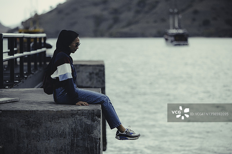 站在桥上向下看的年轻亚洲女人图片素材