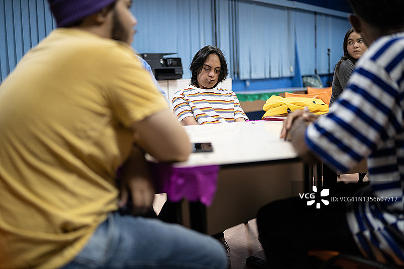 在教室里交谈的青少年学生，包括一名有特殊需要的学生图片素材