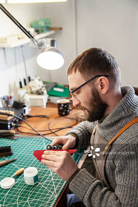 皮革匠人在工作场所使用烙铁图片素材