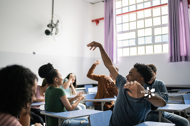 学生在教室里用纸团打闹玩耍图片素材