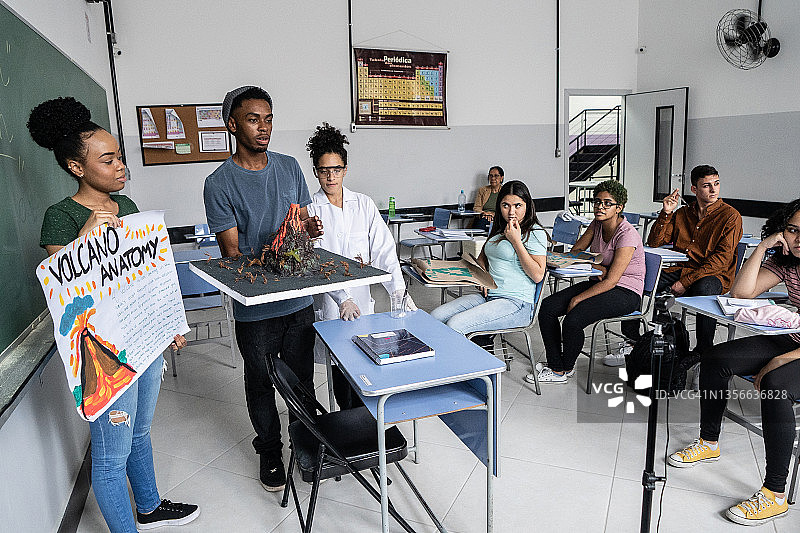 青少年学生在教室里向同学和网络摄像头做演示图片素材