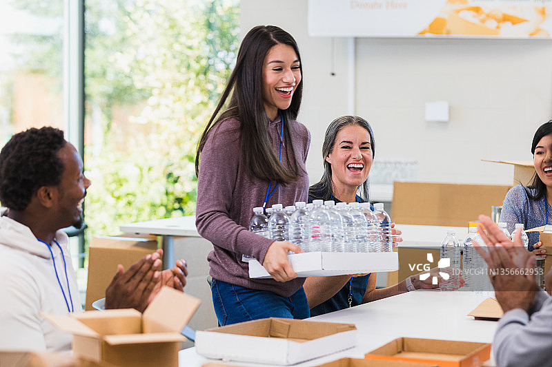 年轻女人向食物银行捐赠瓶装水图片素材