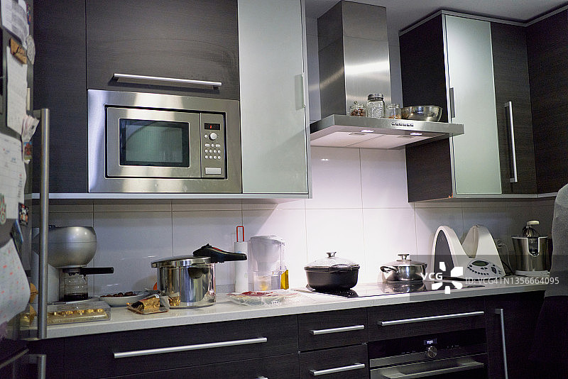 美丽的现代厨房，白色瓷砖背景和厨房用具在柜台上图片素材