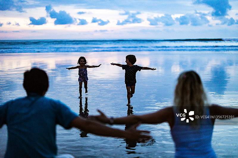 孩子们在海滩上奔向父母的怀抱图片素材