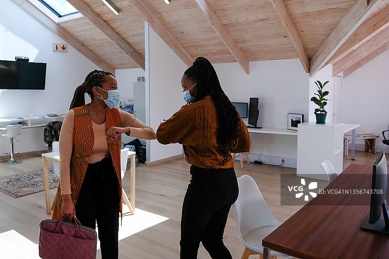 非洲裔女人返回工作岗位并问候她的同事图片素材
