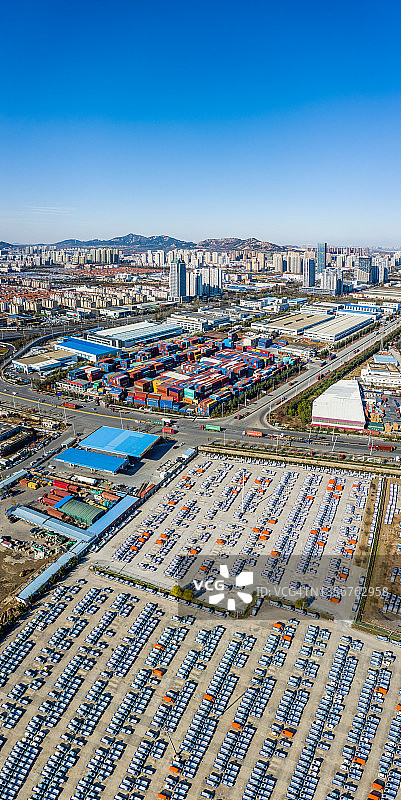 青岛城市天际线前停放的新车和厢式货车无人机航拍图片素材