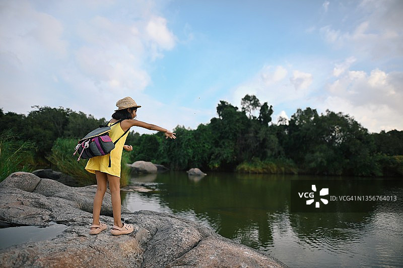 女孩在水中扔石头图片素材
