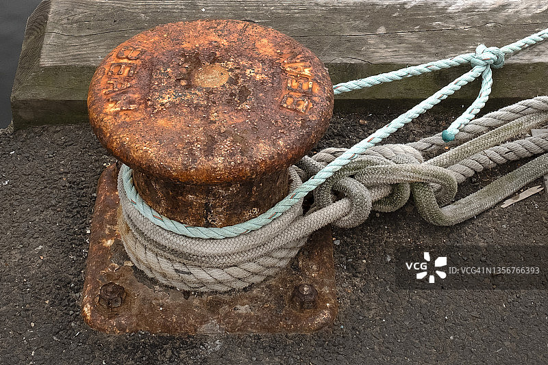 系在锈迹斑斑的系泊柱上的绳索图片素材