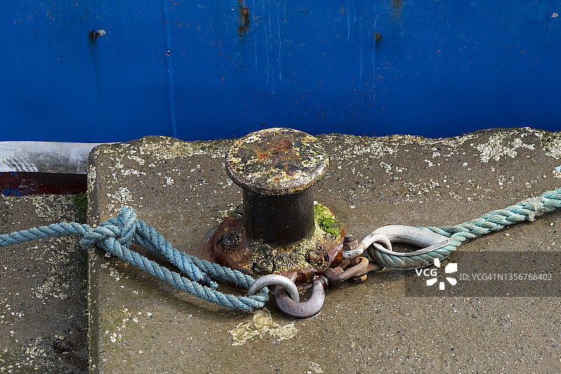 系在锈迹斑斑的系泊柱上的绳索图片素材