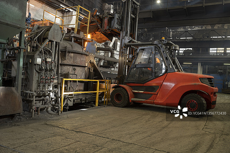 使用叉车将液态熔融金属倒入铸模中图片素材