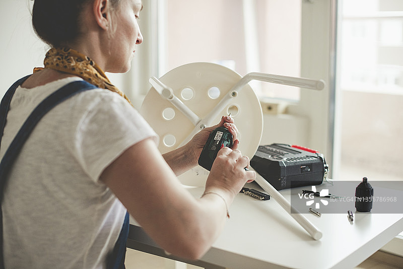 在工作室使用电动螺丝刀的女人图片素材