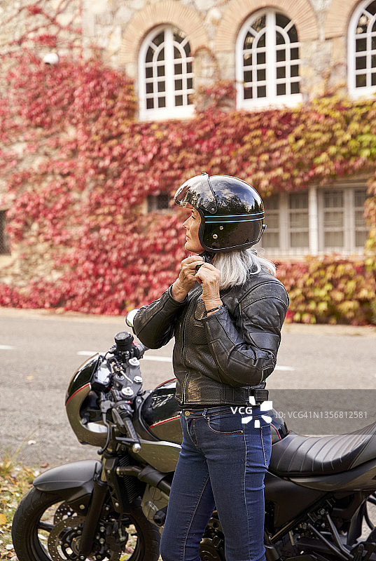 戴摩托车头盔的中年妇女图片素材