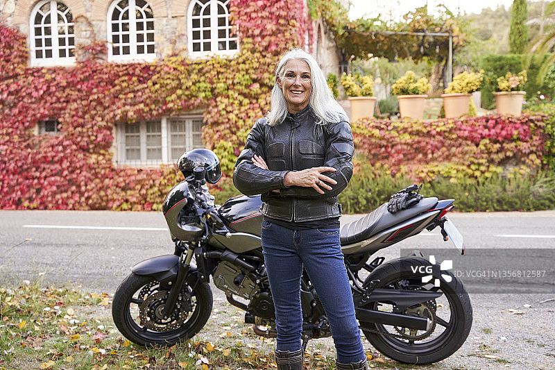 站在摩托车前的中年妇女图片素材