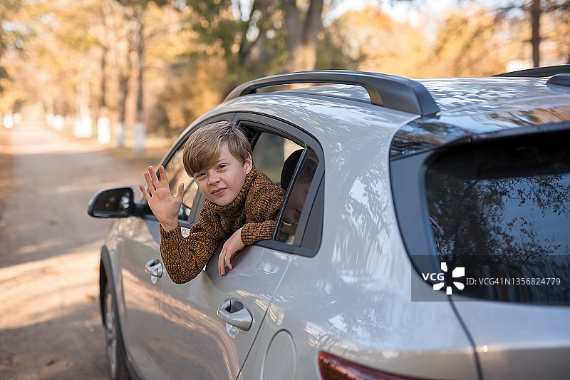 快乐的男孩望着车窗外，假日休闲旅行概念图片素材