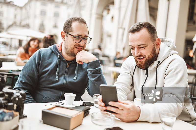 年轻开发人员向同事展示新的改进版手机App图片素材