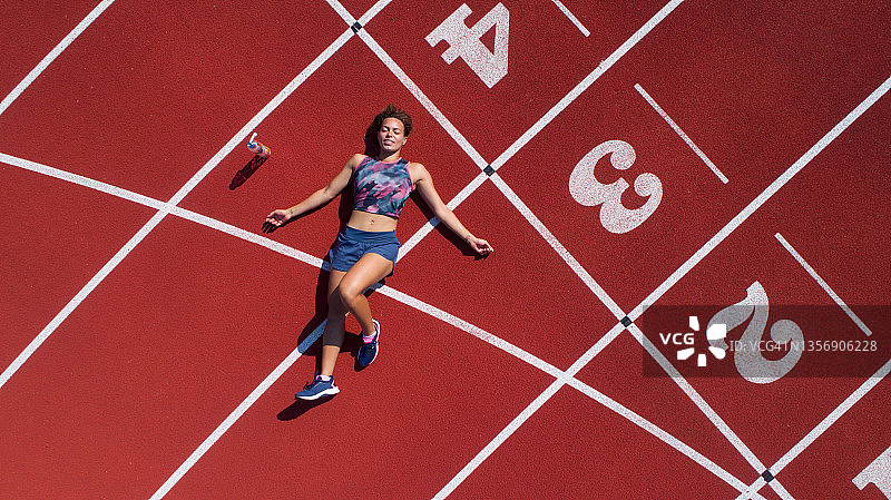 女子在跑道上伸展身体图片素材