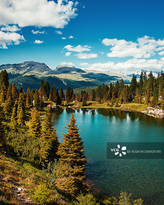 科尔布里孔湖与松树林，蓝色多云的天空 - 特伦蒂诺-上阿迪杰，意大利图片素材