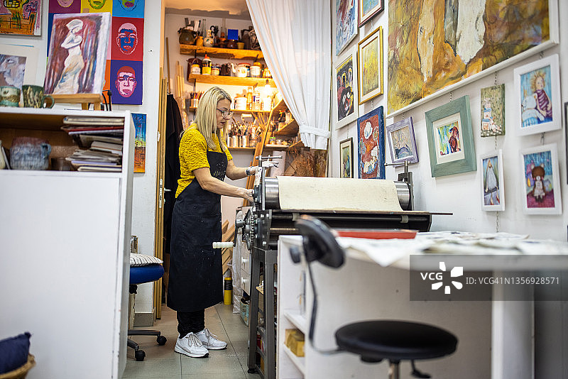 在石版印刷工作室里准备艺术设备的女艺术家图片素材