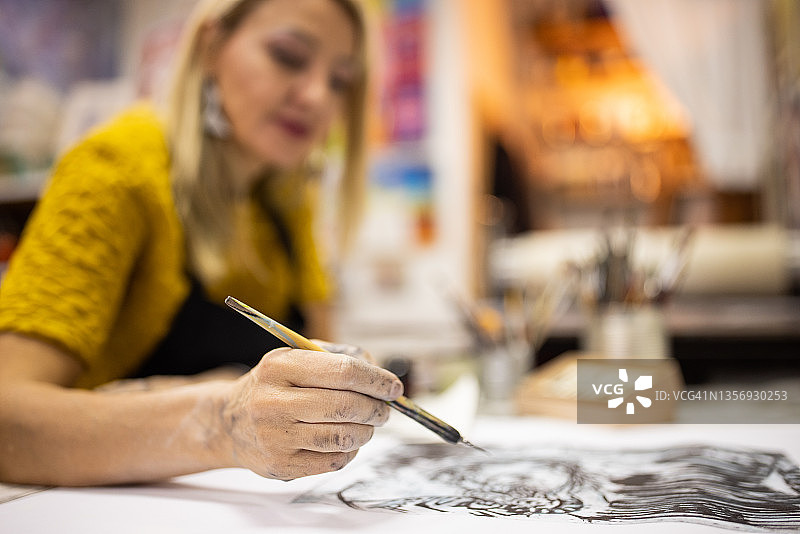 女艺术家为石版画作品添加细节图片素材