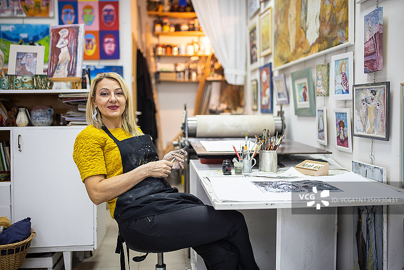 自豪的女艺术家在舒适的艺术工作室创作艺术品图片素材