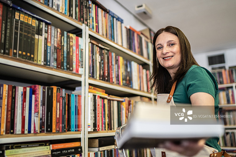 书店店员向顾客递书的肖像图片素材