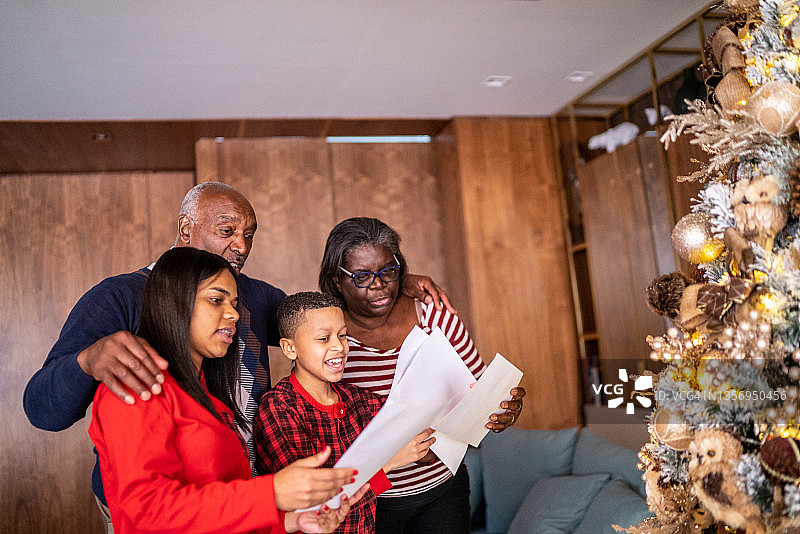 在家阅读圣诞贺卡的家庭图片素材