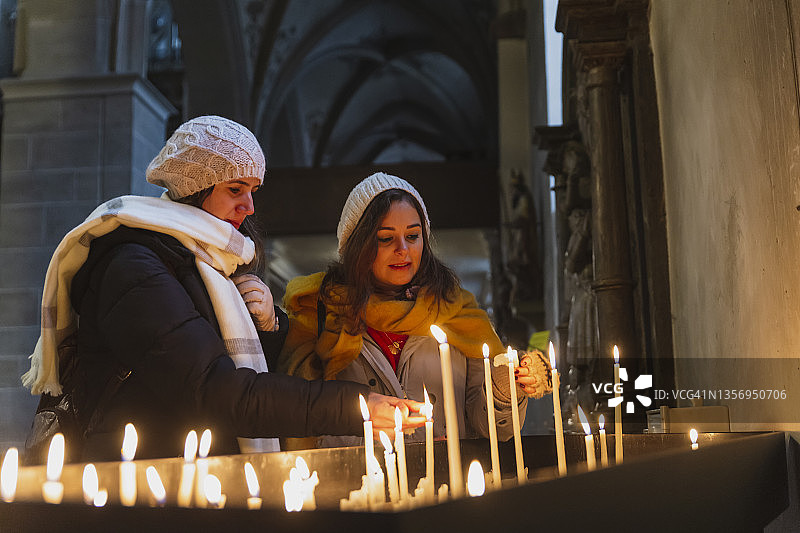 教堂里的女人，点燃蜡烛图片素材
