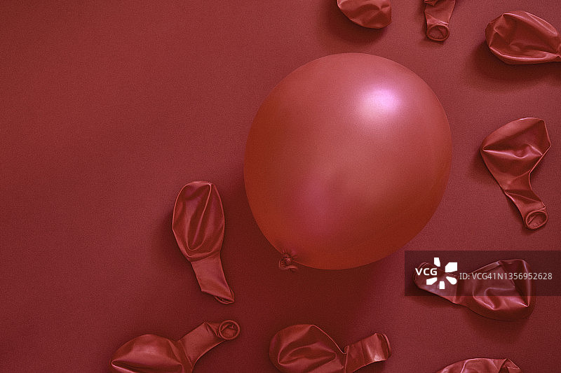 红色气球的单色图像，其中一个在红色纸面上充气图片素材