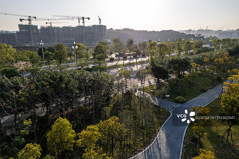 远处阳光明媚的树林和建筑工地的鸟瞰图图片素材