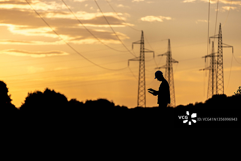 戴头盔和安全背心的电气工程师正在工作图片素材