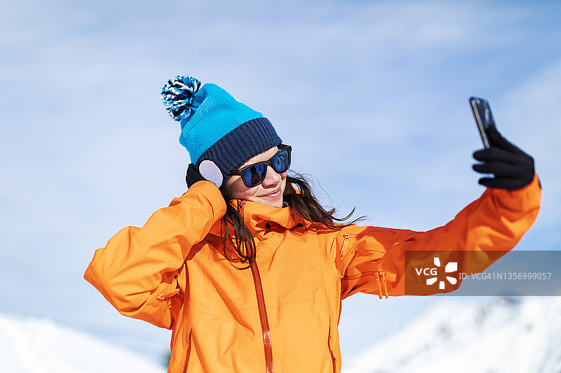 在山区滑雪胜地自拍的年轻女人图片素材