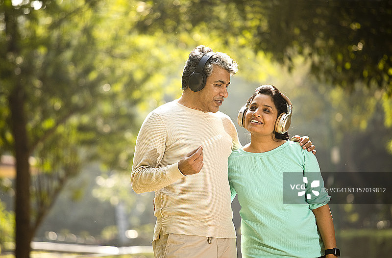 情侣在公园用耳机听音乐图片素材