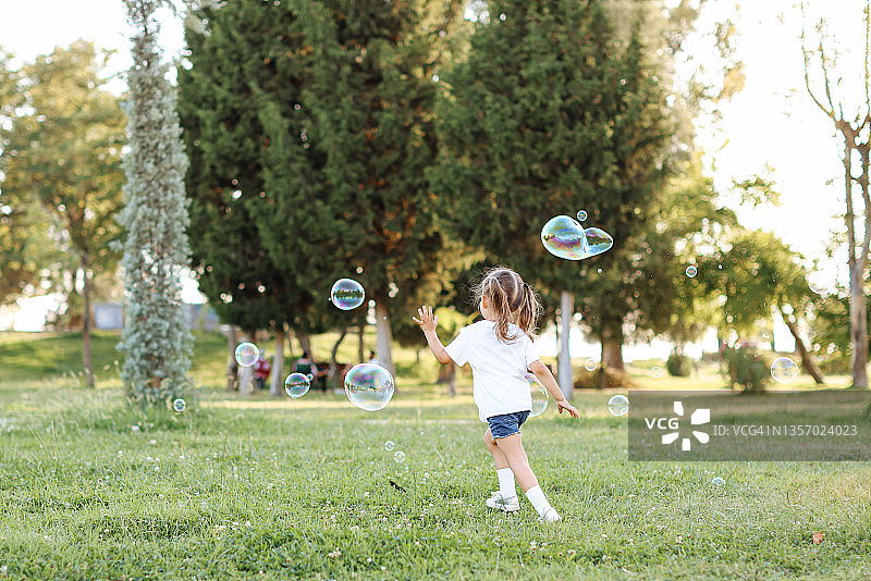 户外吹泡泡的可爱小女孩图片素材