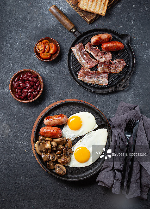 黑色煎锅和黑色盘子上丰盛的英式早餐图片素材