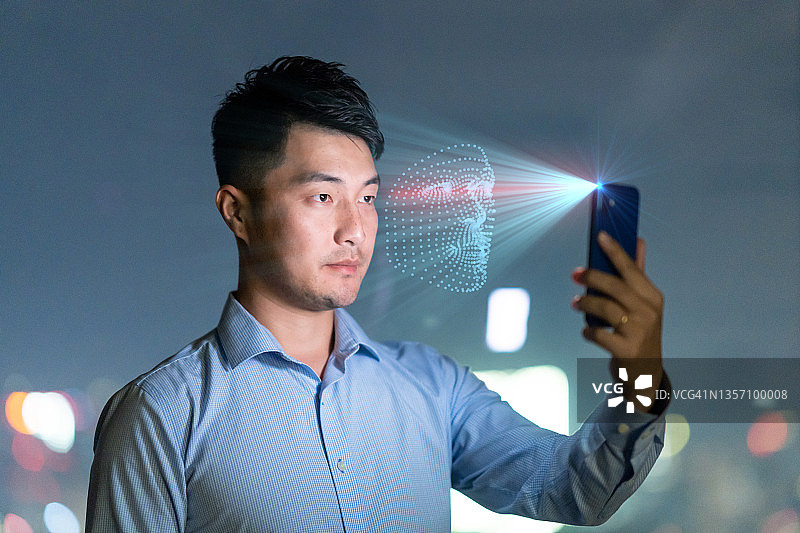 青年男子使用手机进行面部识别图片素材