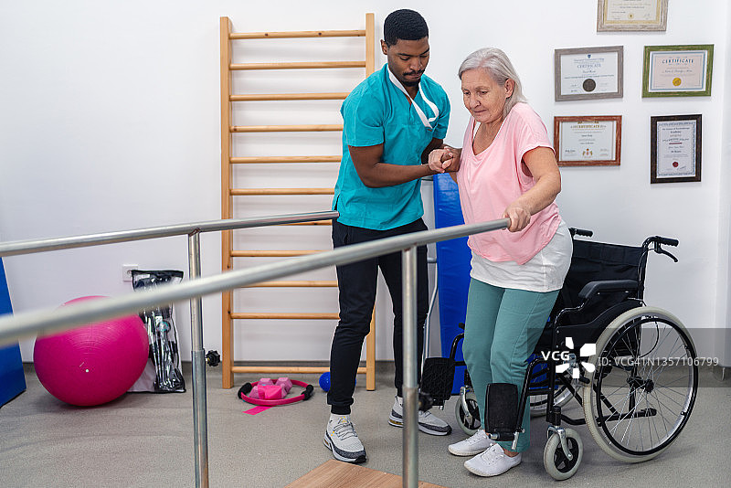 老年患者在理疗师的帮助下在诊所做理疗图片素材