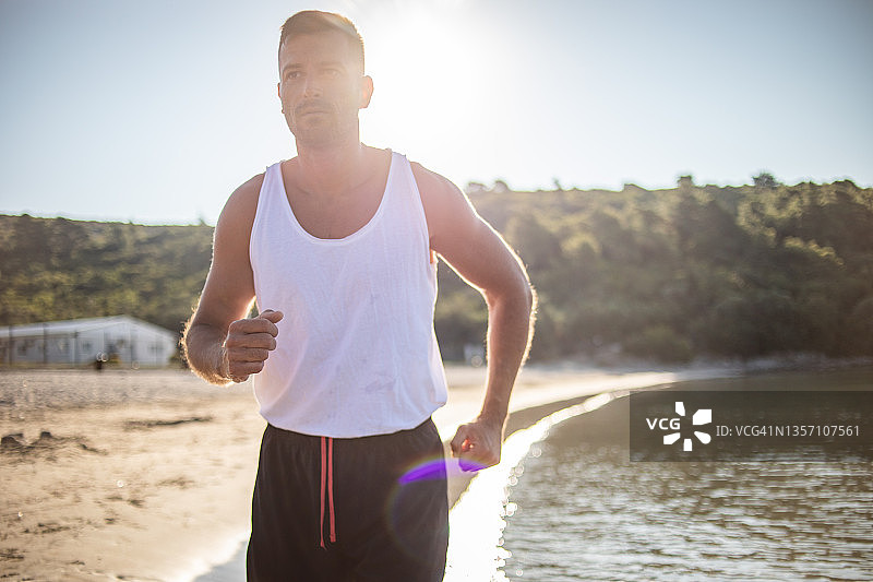 男人在热带海滩上奔跑图片素材