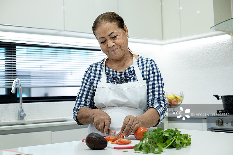 年长的女人在家切菜图片素材