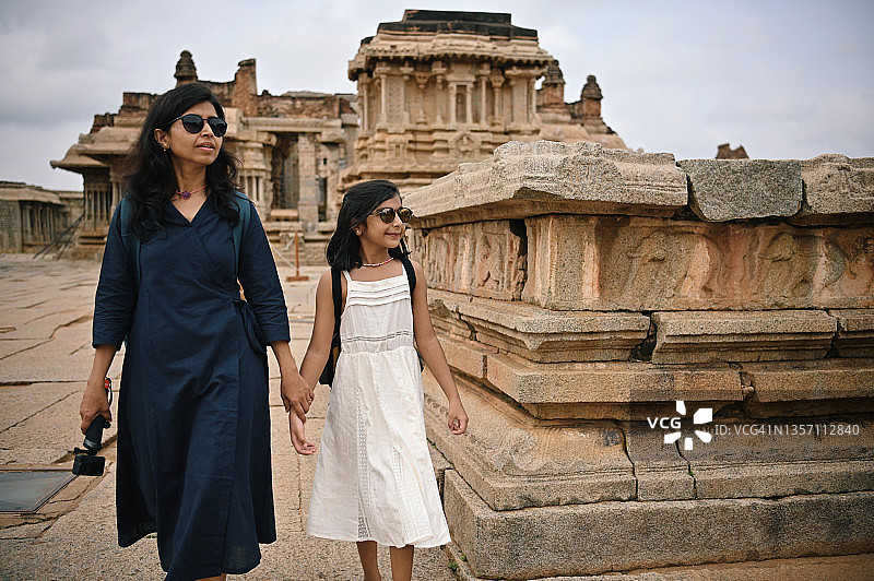 母亲和女儿走在卡纳塔克邦亨比一座古老石庙的遗址中图片素材